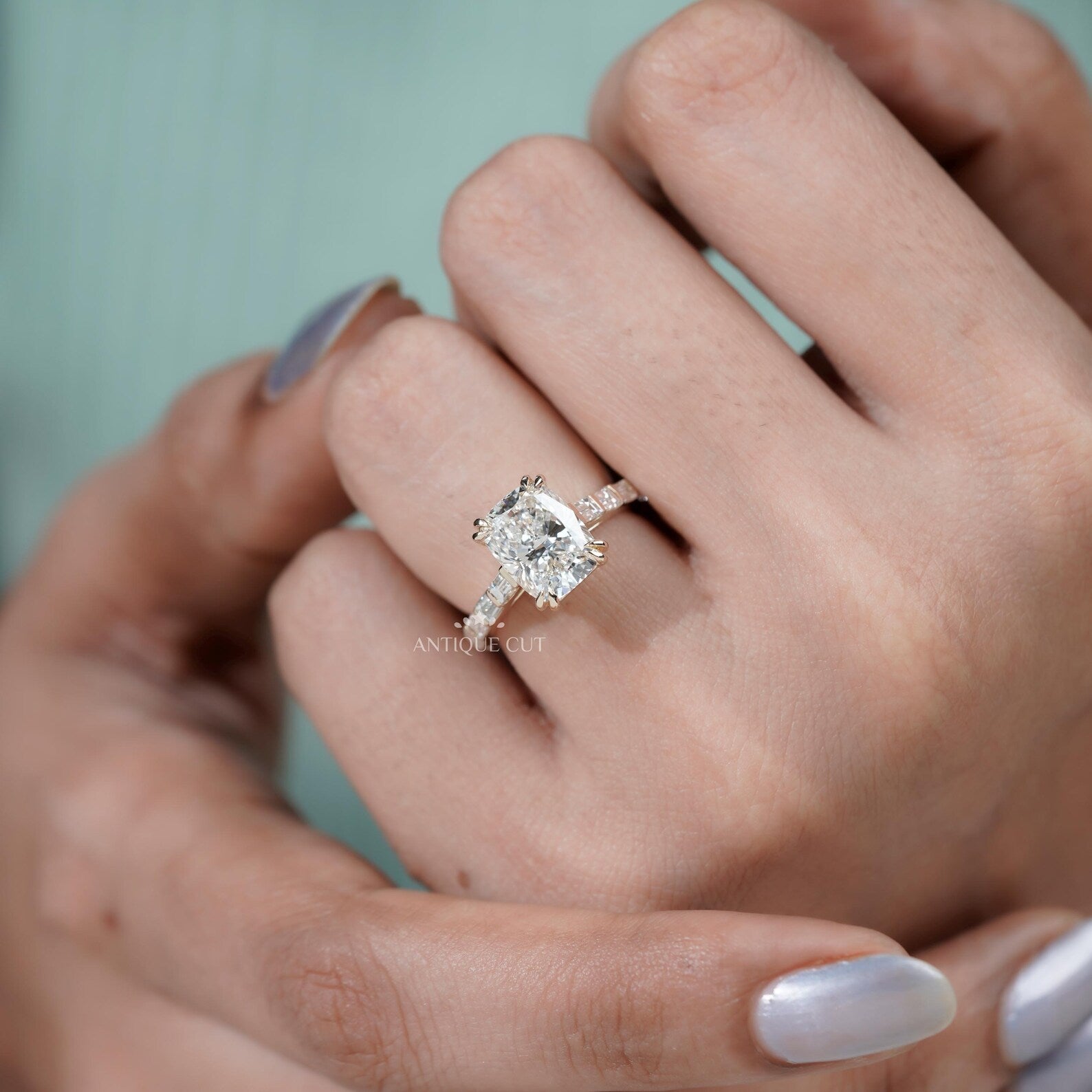 Cushion cut yellow gold engagement ring with double claw prongs and diamond pavé band