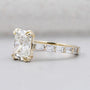 Yellow gold cushion cut engagement ring with double claw prongs and pavé diamonds