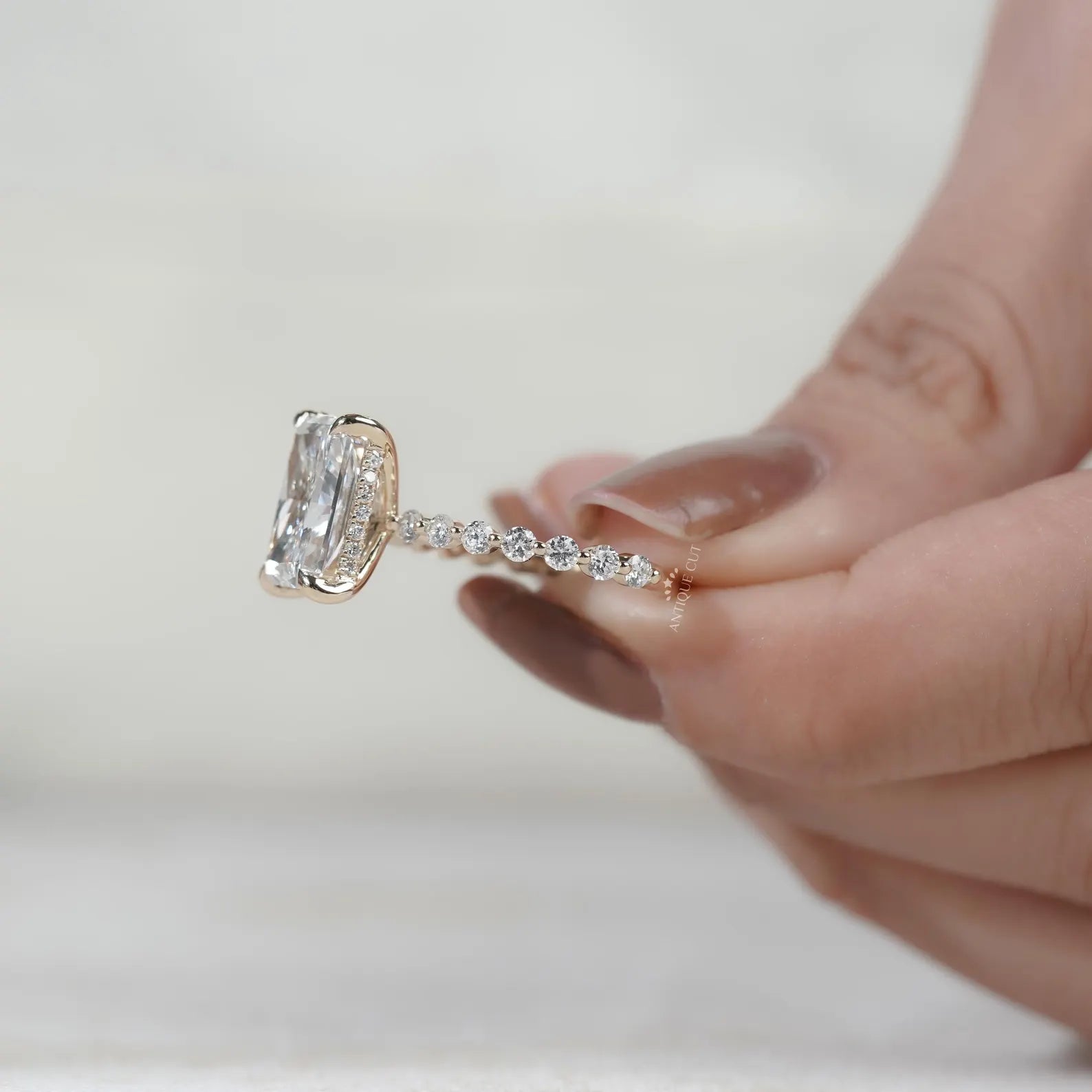 Yellow gold lab grown diamond engagement ring with radiant cut center and hidden halo