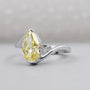 Pear shaped yellow diamond ring with white gold bypass setting