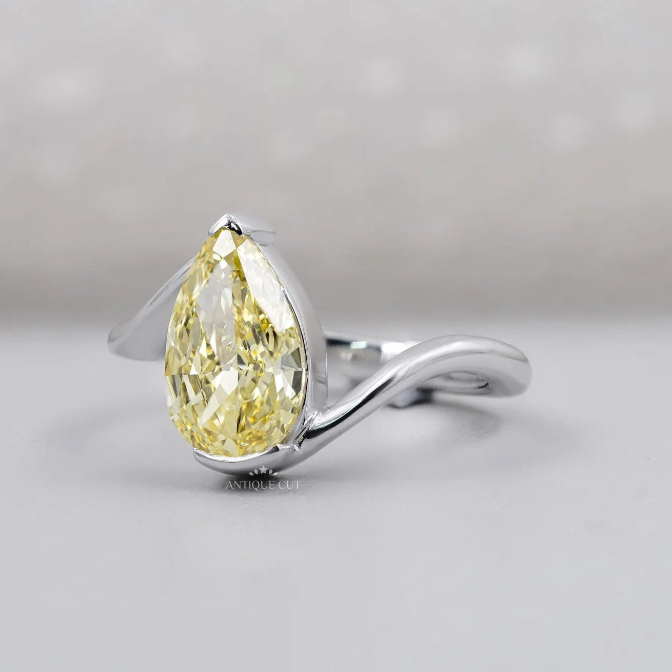 Pear shaped yellow diamond ring with white gold bypass setting