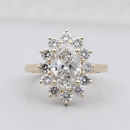 Oval cluster halo engagement ring in yellow gold