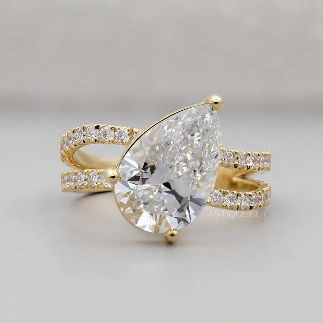 Pear cut engagement ring with split shank pave band in yellow gold