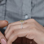 Yellow diamond ring on a hand with a blurred background