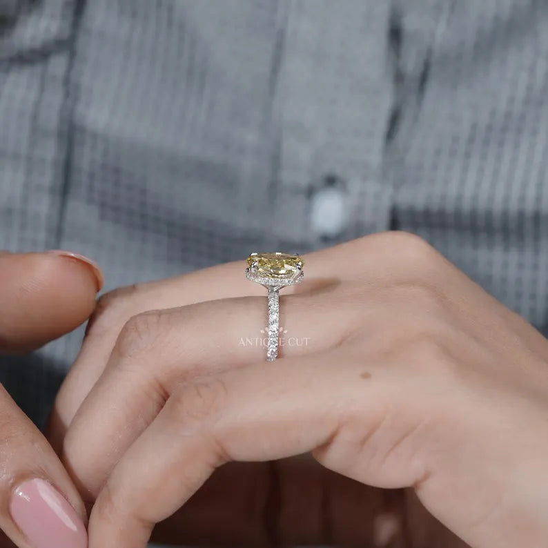 Yellow diamond ring on a hand with a blurred background