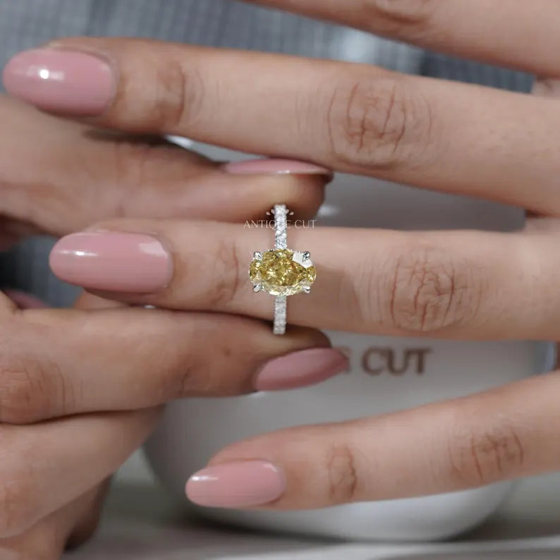 Yellow diamond ring on a hand with a blurred background