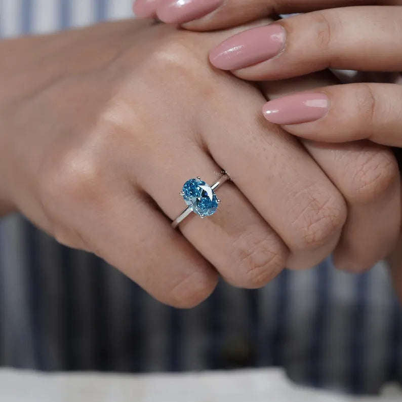 Silver ring with a blue gemstone on a light gray background