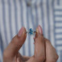 Silver ring with a blue gemstone on a light gray background