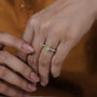Close-up of a hand wearing a diamond ring with a blurred background

