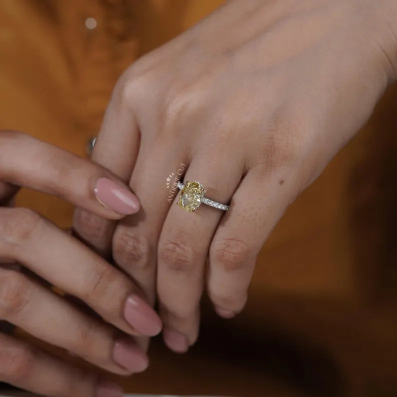 Close-up of a hand wearing a diamond ring with a blurred background

