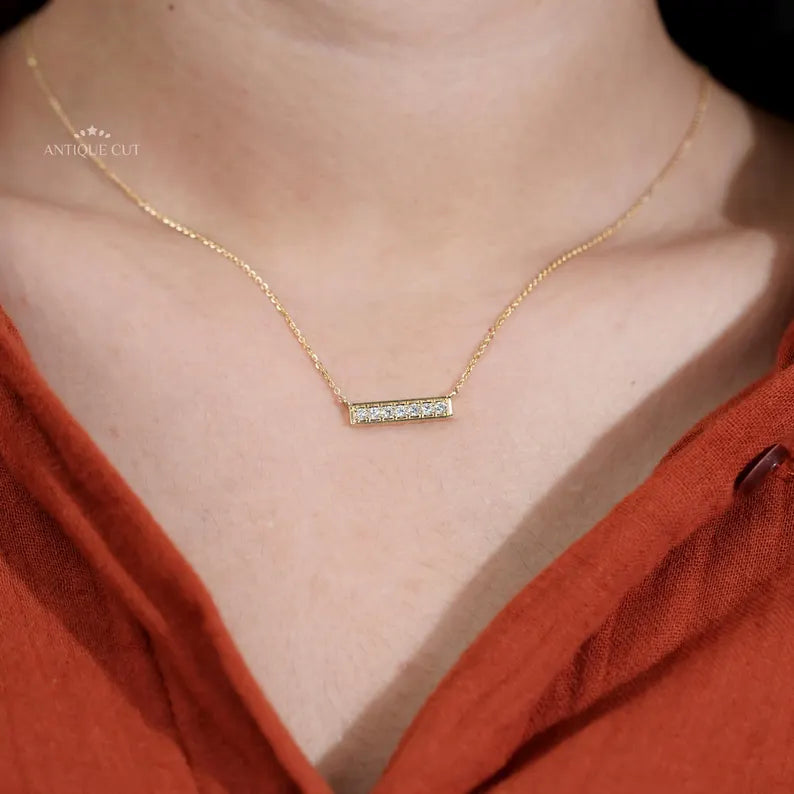 This yellow gold bar necklace is decorated with fine diamonds.