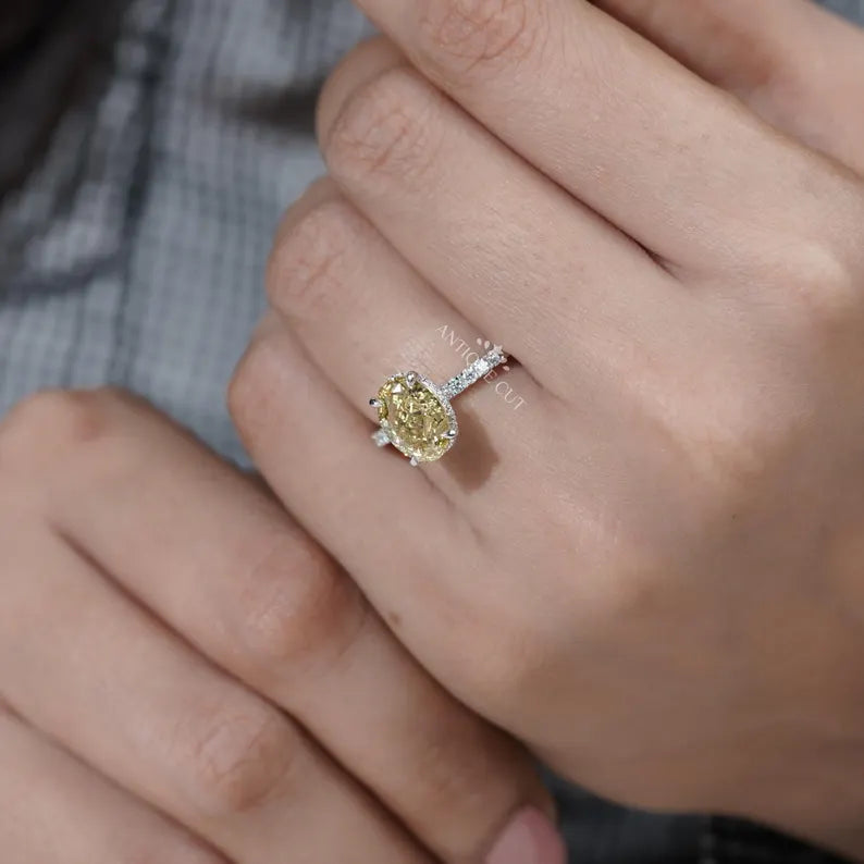 Yellow diamond ring on a hand with a blurred background