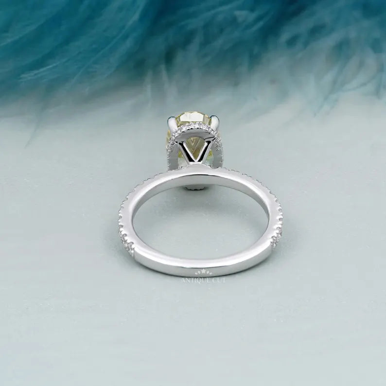 Ring with a yellow diamond and smaller diamonds on a light blue background