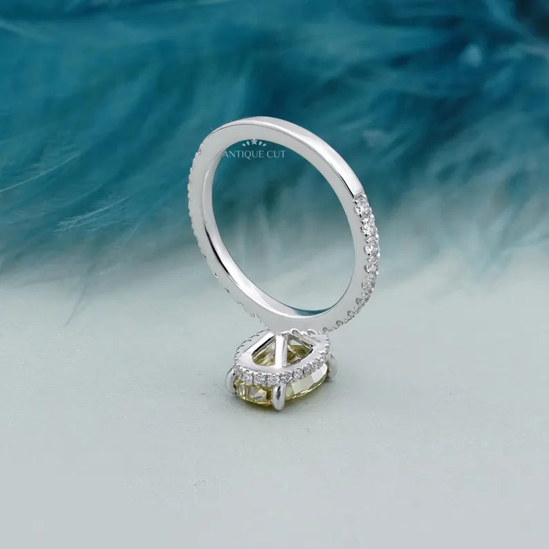 Ring with a yellow diamond and smaller diamonds on a light blue background