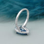 Pear shape blue diamond ring with halo and pave band