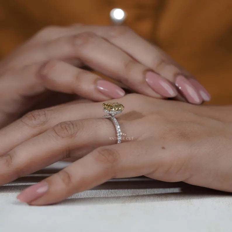 Close-up of a hand wearing a diamond ring with a blurred background
