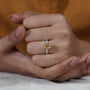Close-up of a hand wearing a yellow diamond ring on a natrual background