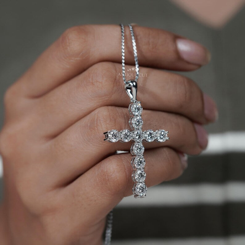 Gold cross necklace with diamonds on a person's neck

