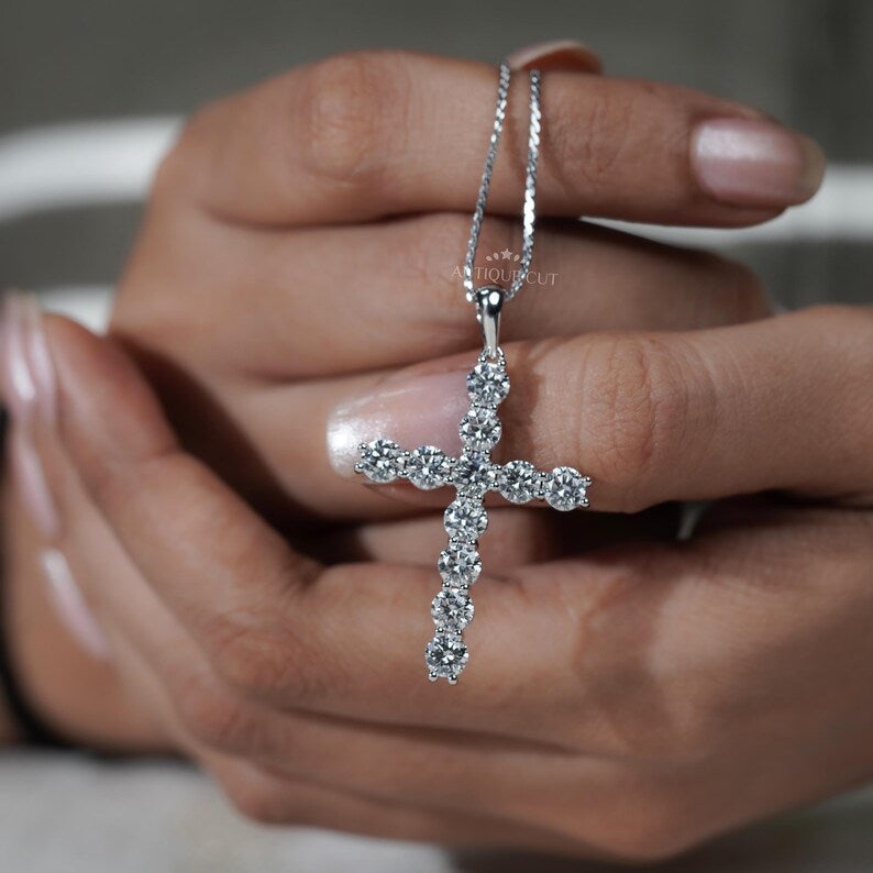 Gold cross necklace with diamonds on a person's neck

