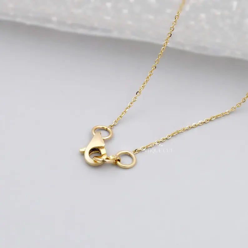 This image shows a close-up of a gold necklace clasp and chain.