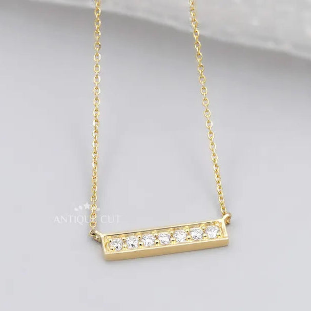 This is a gold diamond bar necklace with a modern design.