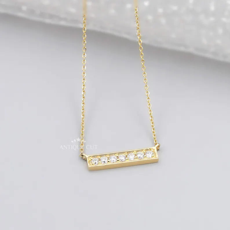 This is a gold diamond bar necklace with a modern design.