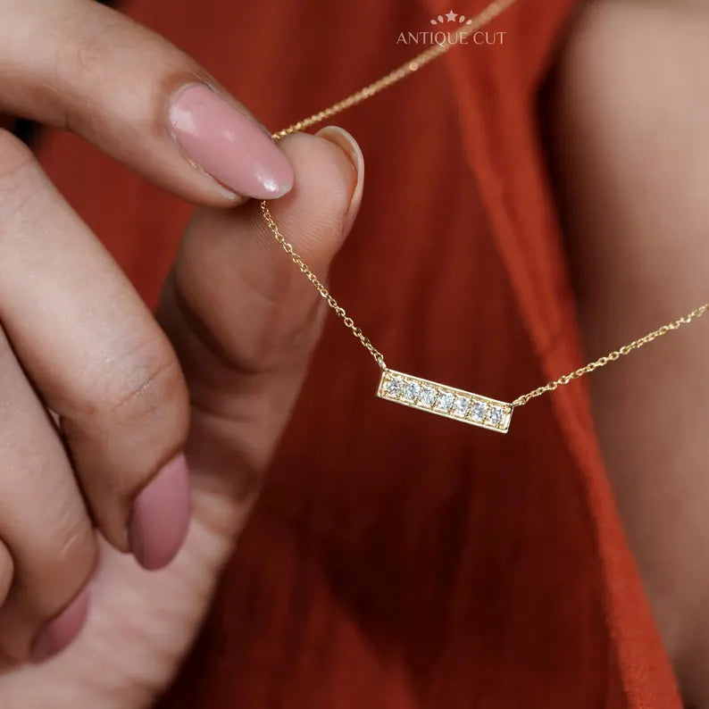 This gold and diamond bar necklace looks stylish and classy.