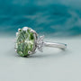 Oval green diamond ring with side stones elegant design