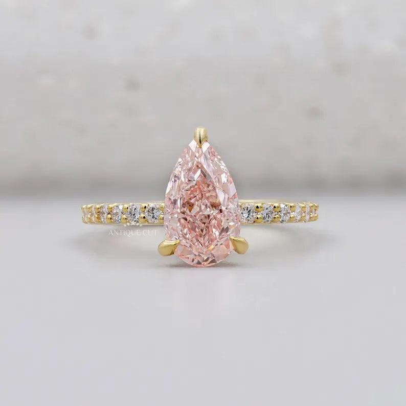 Pink diamond teardrop ring in yellow gold.