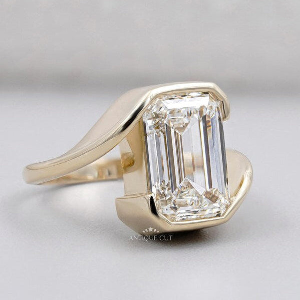 Emerald cut diamond ring in bezel setting