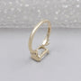 Contemporary emerald cut diamond ring in horizontal bezel yellow gold