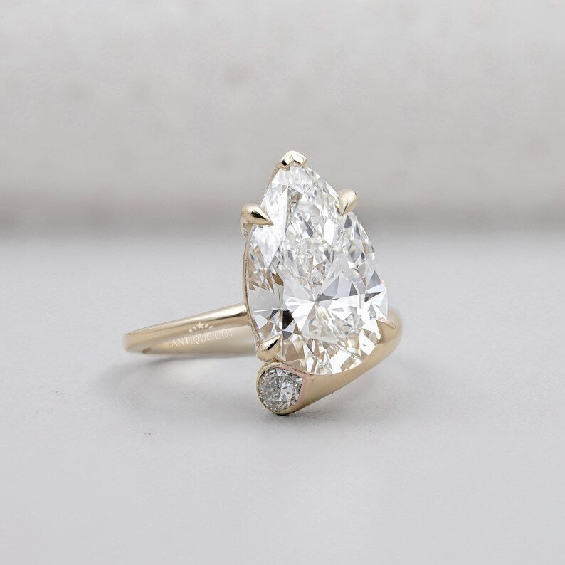 Yellow gold pear cut diamond engagement ring with side stones