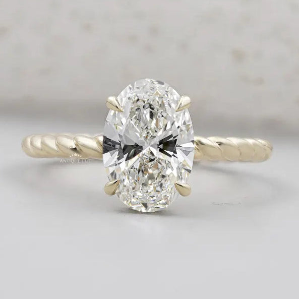 Oval cut engagement ring with twisted gold band