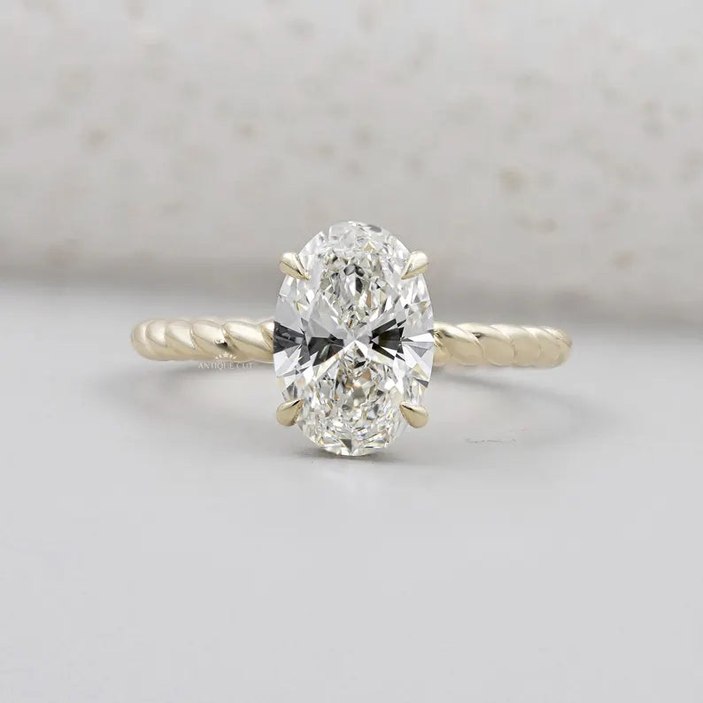 Oval cut engagement ring with twisted gold band