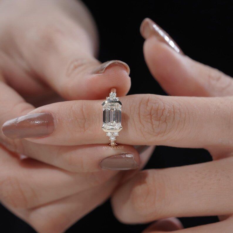 Step cut emerald diamond ring with bezel setting in yellow gold