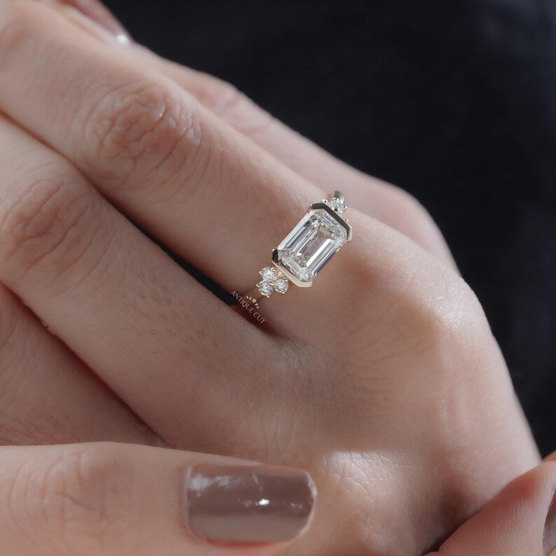 East west emerald diamond ring with clean geometric yellow gold band