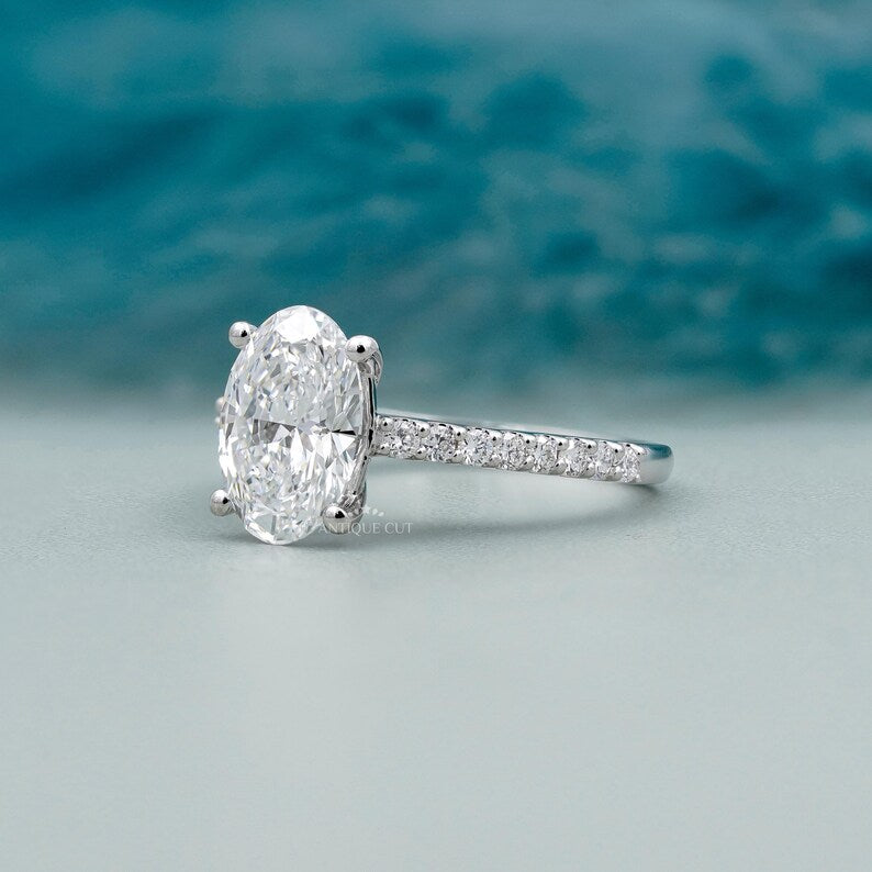 Oval solitaire diamond ring with white gold pave band