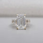 Emerald cut diamond engagement ring with tapered side stones in yellow gold
