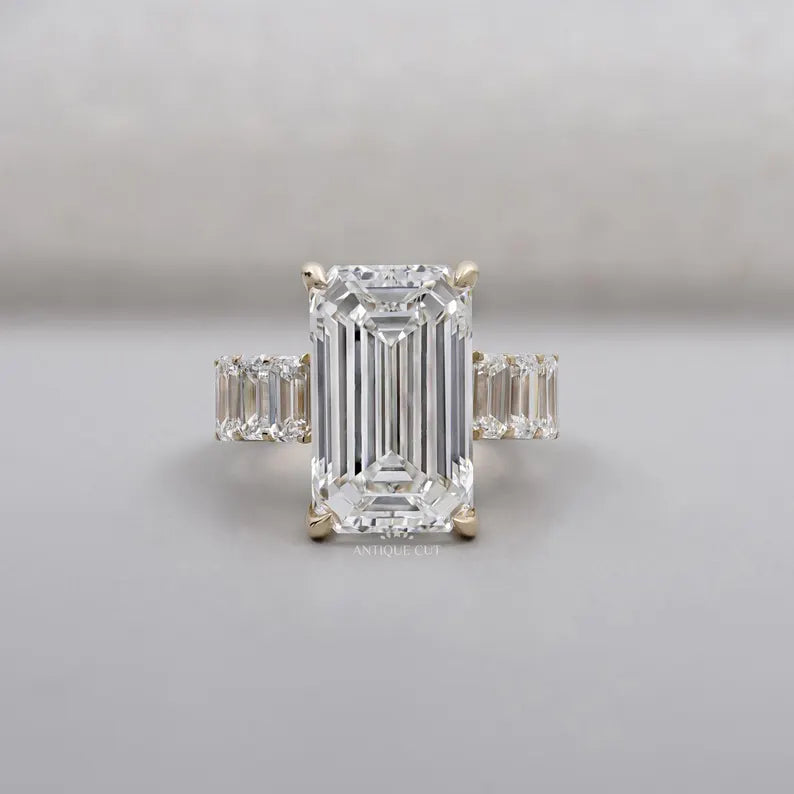 Emerald cut diamond engagement ring with tapered side stones in yellow gold