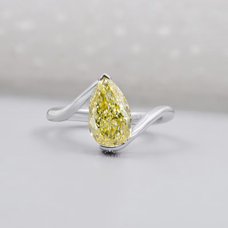 Pear shaped yellow diamond ring in white gold, top view