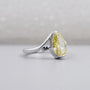 Side view of pear shaped yellow diamond bypass ring