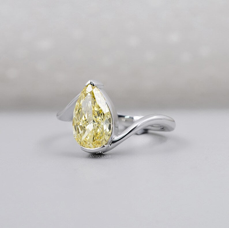 Close-up of pear shaped yellow diamond in white gold setting
