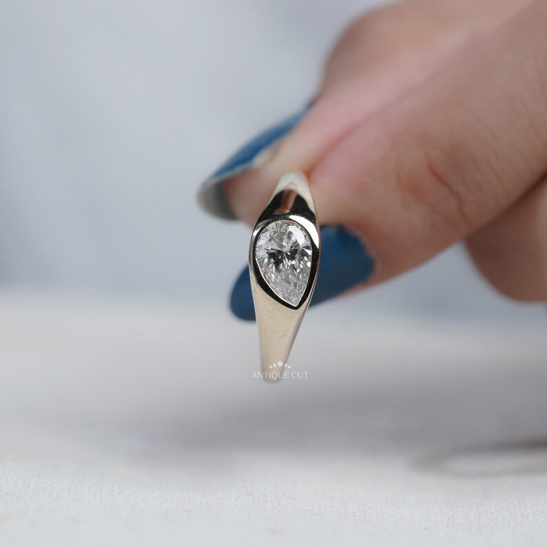 Pear bezel ring with protective pointed-end setting
