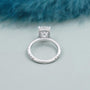 White gold cushion cut solitaire engagement ring with sparkling hidden halo diamonds.