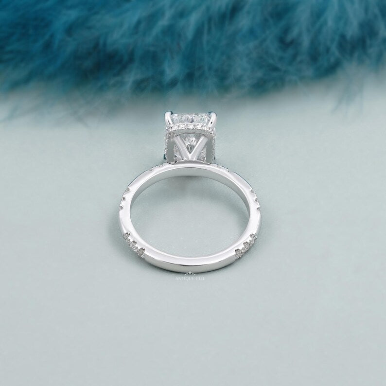 White gold cushion cut solitaire engagement ring with sparkling hidden halo diamonds.