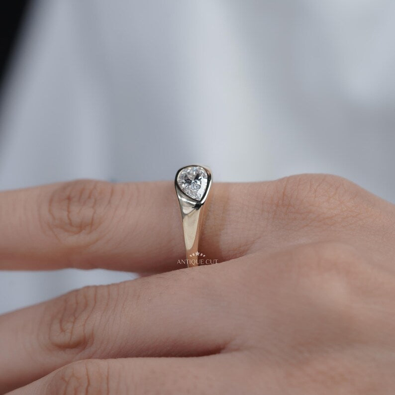 Wide shoulder ring with bezel set pear center stone