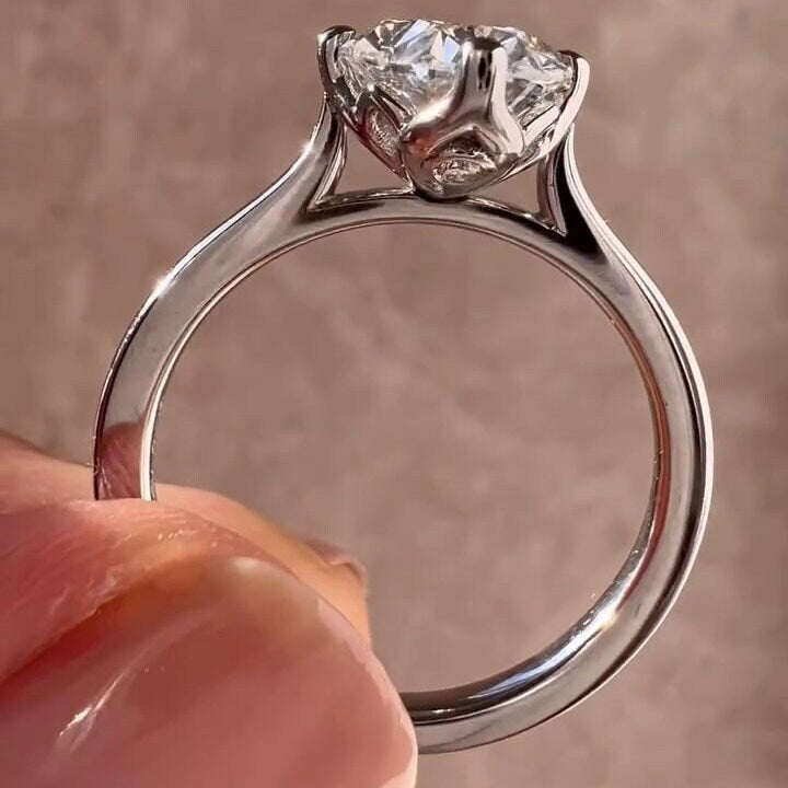 Oval solitaire engagement ring featuring a sculpted tulip setting