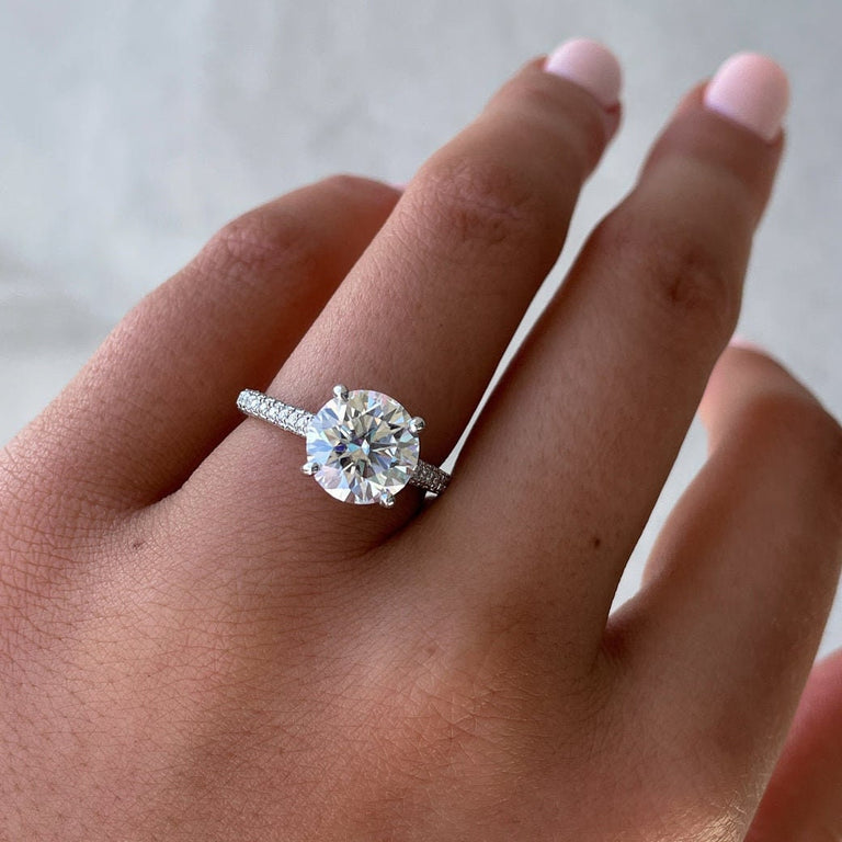 Round hidden halo engagement ring with pavé diamond band in white gold
