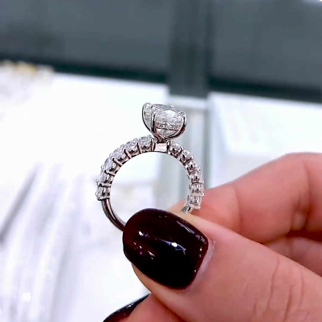 Oval diamond engagement ring with pavé band and oval diamond side stones
