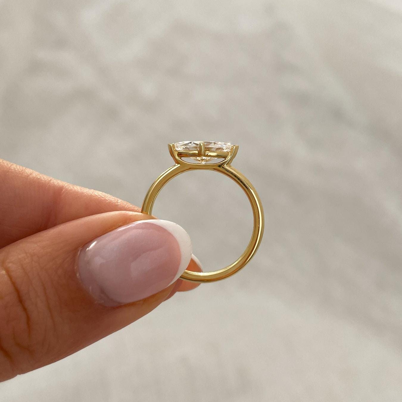 Yellow gold engagement ring with east-west marquise diamond